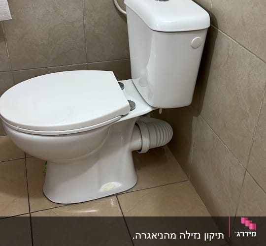 אסלה לבנה מותקנת בחדר אמבטיה עם אריחים